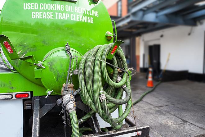 a grease trap being pumped by a sanitation technician in Hyde Park MA